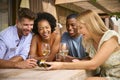 Group Of Smiling Multi-Cultural Friends Looking At Retro Camera Outdoors At Home Drinking Wine Together Royalty Free Stock Photo