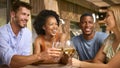 Group Of Smiling Multi-Cultural Friends Outdoors At Home Drinking Wine Together Royalty Free Stock Photo