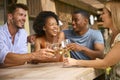 Group Of Smiling Multi-Cultural Friends Outdoors At Home Drinking Wine Together Royalty Free Stock Photo