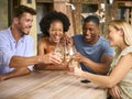 Group Of Smiling Multi-Cultural Friends Outdoors At Home Drinking Wine Together Royalty Free Stock Photo