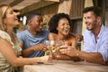 Group Of Smiling Multi-Cultural Friends Outdoors At Home Drinking Wine Together Royalty Free Stock Photo