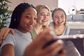 Group Of Smiling Multi-Cultural Teenage Girl Friends Posing For Selfie On Mobile Phone At Home Royalty Free Stock Photo