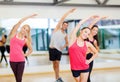 Group of smiling people stretching in the gym