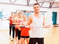 Group of smiling people working out with barbells