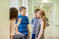 Group of smiling school kids talking in corridor Royalty Free Stock Photo