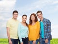 Group of smiling teenagers over blue sky and grass Royalty Free Stock Photo