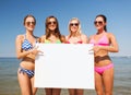 Group of smiling women with blank board on beach Royalty Free Stock Photo