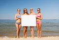 Group of smiling women with blank board on beach Royalty Free Stock Photo