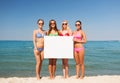 Group of smiling women with blank board on beach Royalty Free Stock Photo