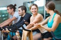 Group smiling working out of cycling in fitness club Royalty Free Stock Photo