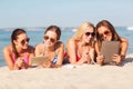 Group of smiling young women with tablets on beach Royalty Free Stock Photo