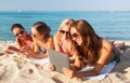 Group of smiling young women with tablets on beach Royalty Free Stock Photo