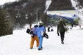 Group of snowboarders walking toward a chairlift in the snow