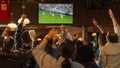 Group of Soccer Fans Cheering, Screaming, Raising Hands and Jumping During a Football Game Live Royalty Free Stock Photo