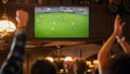 Group of Soccer Fans Watching a Live Football Match Broadcast in a Sports Pub on TV. People Cheering Royalty Free Stock Photo