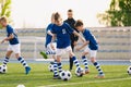 Group of Soccer Team Players on Training Session with Coach. Happy Kids Kicking Football Balls Royalty Free Stock Photo
