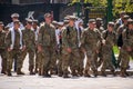 Group of soldier cadets are seen walking down a street in formation wearing their fatigue uniforms