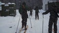 Group of soldiers run on skis in the woods with weapons. Clip. Soldiers with AK-47 rifles and grenade launchers running Royalty Free Stock Photo