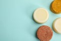 Group of solid shampoo bars on turquoise background, flat lay. Space for text