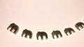 A group of souvenir sculptures of elephants mascots in backlight.