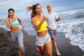 Group of sport people running on the beach