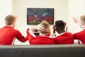 Group Of Sports Fans Watching Game On TV At Home