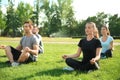 Group of sporty people practicing yoga in park Royalty Free Stock Photo