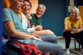 Group of sporty poeple in gym dressing room, sitting and having conversation Royalty Free Stock Photo