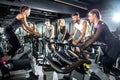 Group of sporty women and men training on exercise bikes together at gym Royalty Free Stock Photo