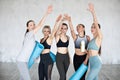 Group sporty women rejoice raising their hands up at gym. Team, friendship and helthy lifestyle Royalty Free Stock Photo