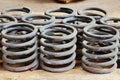 Group of steel springs of shock absorbers on wooden palete. Spare parts of heavy industrial machinery