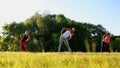 Group stretching workout, large group stretches outdoor on a green grass in park