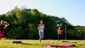 Group stretching workout, large group stretches outdoor on a green grass in park