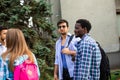 Group of studens stand at the campus and discuss lessons