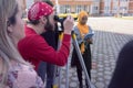 Group of students of architecture doing practice lessons as Surveyor Engineering. SurveyorÃ¢â¬â¢s telescope at construction site for