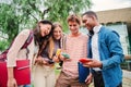 Group of students having fun together sharing on the social media with a cellphone app. Happy friends using their Royalty Free Stock Photo