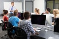 Group Of Students With Male Tutor In Computer Class