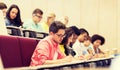 Group of students with notebooks in lecture hall Royalty Free Stock Photo