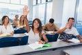 Students raising hands in class on lecture