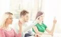 Group of students raising hands in a classroom