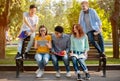 Group Of Students Relaxing Sitting On Bench In Park Outside Royalty Free Stock Photo