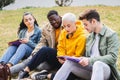 Group of students studying the lesson sitting on grass at the campus park Royalty Free Stock Photo