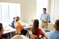 Group of students and teacher with papers or tests