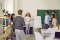 Group of students together with teacher listening to young girl giving presentation in class Royalty Free Stock Photo