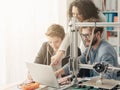 Group of students using a 3D printer and a laptop Royalty Free Stock Photo