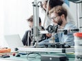 Group of students using a 3D printer and a laptop Royalty Free Stock Photo