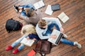 Group of students using smartphones, laptops and reading books Royalty Free Stock Photo