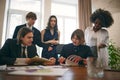 Group of students working on common project while sitting cozy room, class at university. Concept of teamworking Royalty Free Stock Photo