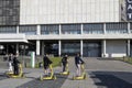 A group of students, young people in black T-shirts on electric scooters ride past the Muzeon