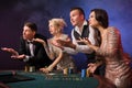 Group of a stylish rich friends are playing poker at casino. Royalty Free Stock Photo